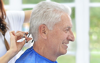 male resident smiling whilst having his haircut