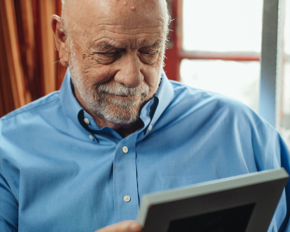 male resident looking at a framed photo of a loved one